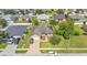 An aerial view of a residential home with solar panels, a brick driveway, and a well-kept lawn in a suburban neighborhood at 311 Bentley Oaks Blvd, Auburndale, FL 33823