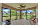 A covered patio with brick flooring, ceiling fan, and screened windows overlooking the lush backyard at 311 Bentley Oaks Blvd, Auburndale, FL 33823