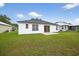 Exterior view of a home featuring a spacious backyard with lush green grass and a concrete patio at 1760 Mountclair Ct, Mount Dora, FL 32757