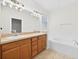 Bathroom featuring a double sink vanity, soaking tub and large mirror at 1760 Mountclair Ct, Mount Dora, FL 32757