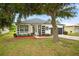 Beautiful home with a well-manicured lawn, mature trees, and an inviting front porch at 1760 Mountclair Ct, Mount Dora, FL 32757