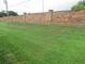 Spacious backyard features a brick wall and lush green lawn at 661 Lake Carolyn Cir, Lakeland, FL 33813