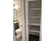 Well-organized bathroom with open shelf for linens, modern vanity and fixtures, and wood-look flooring at 309 Sunnyside Ln, Debary, FL 32713