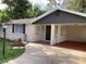 Charming one-story brick home with a covered carport, landscaped yard, and a welcoming front entrance at 309 Sunnyside Ln, Debary, FL 32713