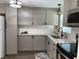 Modern kitchen with stainless steel appliances, stone counters, and grey cabinets at 309 Sunnyside Ln, Debary, FL 32713