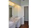 Bathroom featuring double sinks with white cabinetry, marble counters, and laminate floors at 3629 Welsh Way, Lakeland, FL 33813