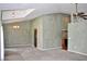 Open-concept living room with high ceilings, neutral carpet, and decorative chandelier at 3629 Welsh Way, Lakeland, FL 33813