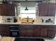 Cozy kitchen features a stainless steel sink, wood cabinets, and bright light from the window at 4119 Chambers St, Lake Wales, FL 33898