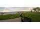 Scenic waterfront view with a bench seat, grassy lawn, docks on the water and a rainbow in the sky at 4119 Chambers St, Lake Wales, FL 33898