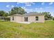 A backyard view of the home featuring a concrete patio and sliding glass doors to the interior at 4189 Homestead Dr, Lakeland, FL 33810