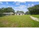 A backyard view of the home featuring a concrete patio and sliding glass doors to the interior at 4189 Homestead Dr, Lakeland, FL 33810