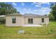 A backyard view of the home featuring a concrete patio and sliding glass doors to the interior at 4189 Homestead Dr, Lakeland, FL 33810