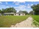 A backyard view of the home featuring a concrete patio and sliding glass doors to the interior at 4189 Homestead Dr, Lakeland, FL 33810