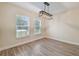 Bright dining area featuring wood-look floors, a modern chandelier, and large windows for natural light at 4189 Homestead Dr, Lakeland, FL 33810