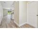 Inviting hallway featuring modern flooring, neutral paint, and a glimpse into a bright, open kitchen at 4189 Homestead Dr, Lakeland, FL 33810