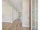 Bright hallway with modern wood-look floors, leading to a series of rooms and featuring closet space at 4189 Homestead Dr, Lakeland, FL 33810