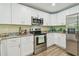 Stylish kitchen with stainless steel appliances, granite countertops, and white cabinets providing ample storage at 4189 Homestead Dr, Lakeland, FL 33810