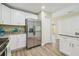 Updated kitchen featuring stainless steel refrigerator, white cabinets, and luxury vinyl plank flooring at 4189 Homestead Dr, Lakeland, FL 33810