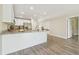 Open kitchen with stainless steel refrigerator, granite counters, white cabinets, and luxury vinyl plank floors at 4189 Homestead Dr, Lakeland, FL 33810