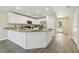 Modern kitchen with white cabinets, granite countertops, stainless steel appliances, and wood-look flooring at 4189 Homestead Dr, Lakeland, FL 33810