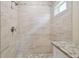 Elegant shower features stone-look tile, pebble accents, and a rain shower head at 4189 Homestead Dr, Lakeland, FL 33810