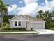 Charming single-story home with gray siding, attached garage, lush landscaping, and a welcoming front porch at 2244 Broadbrook Drive, St Cloud, FL 34771
