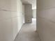 View of a unfinished hallway lined with drywall ready for customization and featuring a glimpse of natural light at 2244 Broadbrook Drive, St Cloud, FL 34771