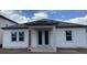 Rear of house with white siding, grey trim, a covered porch and windows at 2373 Broadbrook Drive, St Cloud, FL 34771
