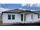 Back exterior featuring a covered porch, white siding, gray trim, and energy-efficient windows at 2373 Broadbrook Drive, St Cloud, FL 34771