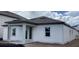 Newly constructed home featuring white horizontal siding, light gray trim, rear covered porch, and dark roof at 2373 Broadbrook Drive, St Cloud, FL 34771