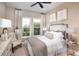 Inviting bedroom with soft lighting, decorative pillows, and a view to the outdoors through bright windows at 852 Arbor Green Trl, St Cloud, FL 34771