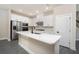 Bright kitchen with white cabinetry, stainless steel appliances, and a large island with quartz countertop at 7728 Somersworth Dr, Kissimmee, FL 34747