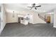 Spacious open-concept living room and kitchen area with modern gray wood flooring and elegant light fixtures at 7728 Somersworth Dr, Kissimmee, FL 34747