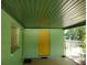 Covered carport with yellow door and green painted walls at 422 22Nd Sw St, Winter Haven, FL 33880