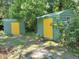 Two green storage sheds with yellow doors in a backyard setting at 422 22Nd Sw St, Winter Haven, FL 33880