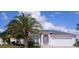 Charming single-story home with a well-manicured lawn, mature palm trees, and a two-car garage at 2514 Sage Dr, Kissimmee, FL 34758