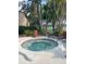 Relaxing hot tub area with lounge chairs, palm trees, and beautiful landscaping at 2928 Lake Pineloch Blvd # 17-26, Orlando, FL 32806