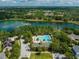 Aerial view showcasing a community pool near a serene lake with lush greenery, offering resort-style living at 319 Ravenshill Way, Deland, FL 32724