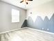 Comfortable bedroom boasts a modern ceiling fan, ample natural light, and wood laminate floors at 319 Ravenshill Way, Deland, FL 32724
