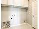 Bright laundry room with overhead cabinets and tile flooring, ready for efficient home management at 319 Ravenshill Way, Deland, FL 32724
