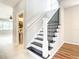 Staircase features a black metal banister, white rails, and black steps leading to the upper level at 319 Ravenshill Way, Deland, FL 32724