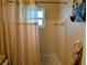 Bathroom featuring a tub with shower curtain, window, and tile walls at 1628 Paradise Ln, Astor, FL 32102