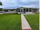 Charming home with a metal roof, manicured lawn, and inviting walkway at 1628 Paradise Ln, Astor, FL 32102