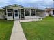 Charming home featuring an enclosed patio and manicured lawn and walkway at 1628 Paradise Ln, Astor, FL 32102