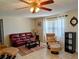 Relax in this cozy living room featuring a leather sofa, ceiling fan, and lots of natural light at 1628 Paradise Ln, Astor, FL 32102