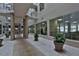 Hallway with view of fitness room with exercise equipment, potted plants, tile flooring and pillars at 3 Oceans West Blvd # 5C4, Daytona Beach Shores, FL 32118