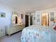 Bedroom showcasing a decorative mirror, patterned bedding, and ensuite bathroom access at 1415 Ocean Shore Blvd # 309, Ormond Beach, FL 32176