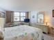 Bright bedroom features a seating area, large dresser, and patterned bedding at 1415 Ocean Shore Blvd # 309, Ormond Beach, FL 32176