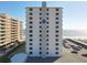 An exterior of a beachfront condominium building with a parking lot and ocean view at 1415 Ocean Shore Blvd # 309, Ormond Beach, FL 32176
