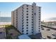 Exterior view of a high-rise building near the ocean, featuring a parking area at 1415 Ocean Shore Blvd # 309, Ormond Beach, FL 32176